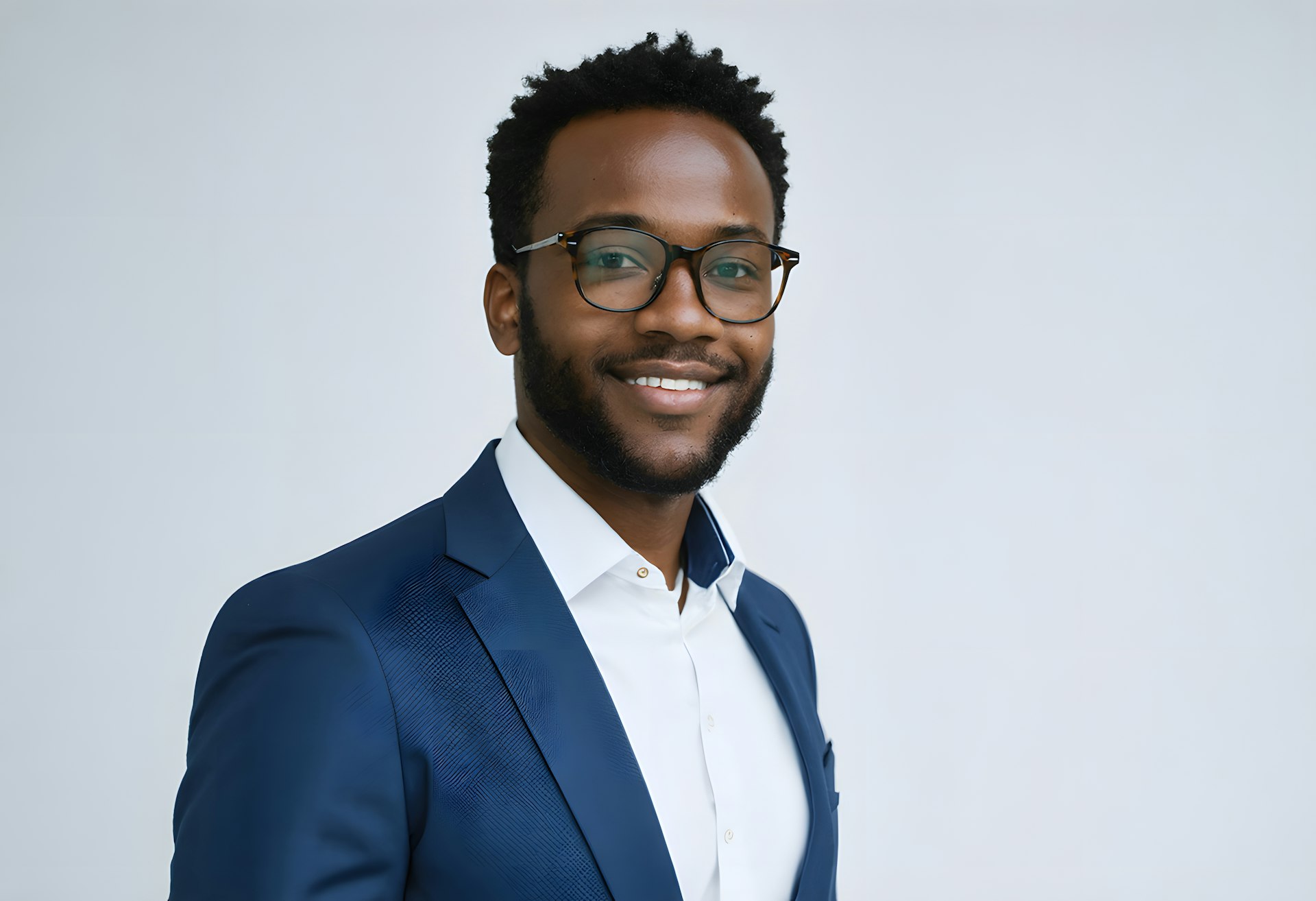 A man in a suit and glasses smiling